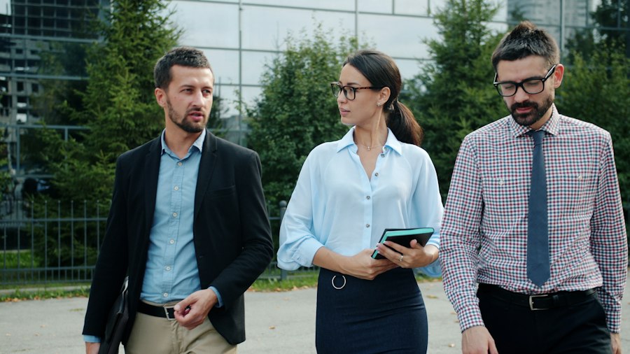 オフィスビルの前を歩く、3人のビジネスパーソン
